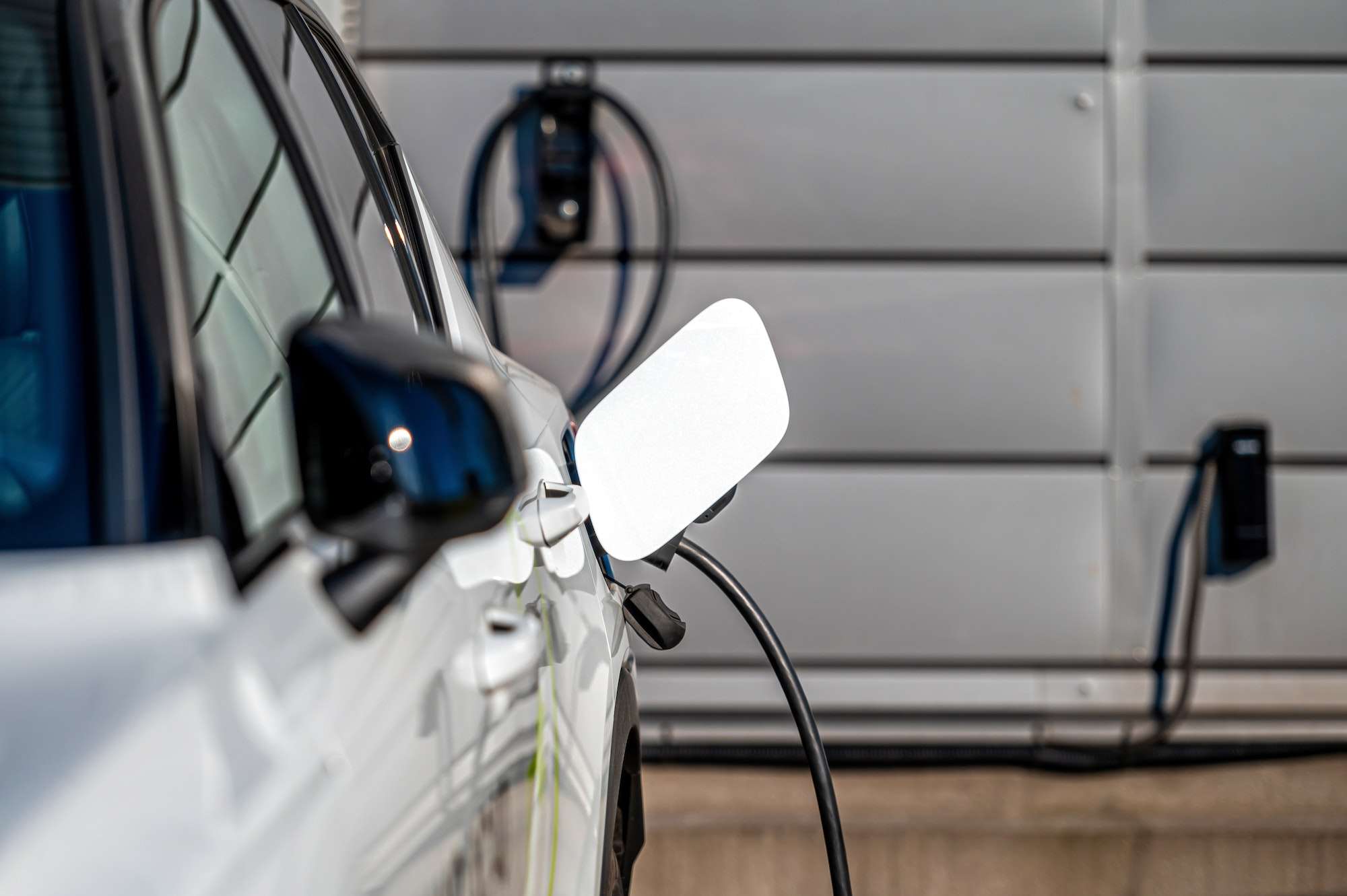 Accueil 1 The electric car charger plugged in to the socket.The modern electric car charging the battery